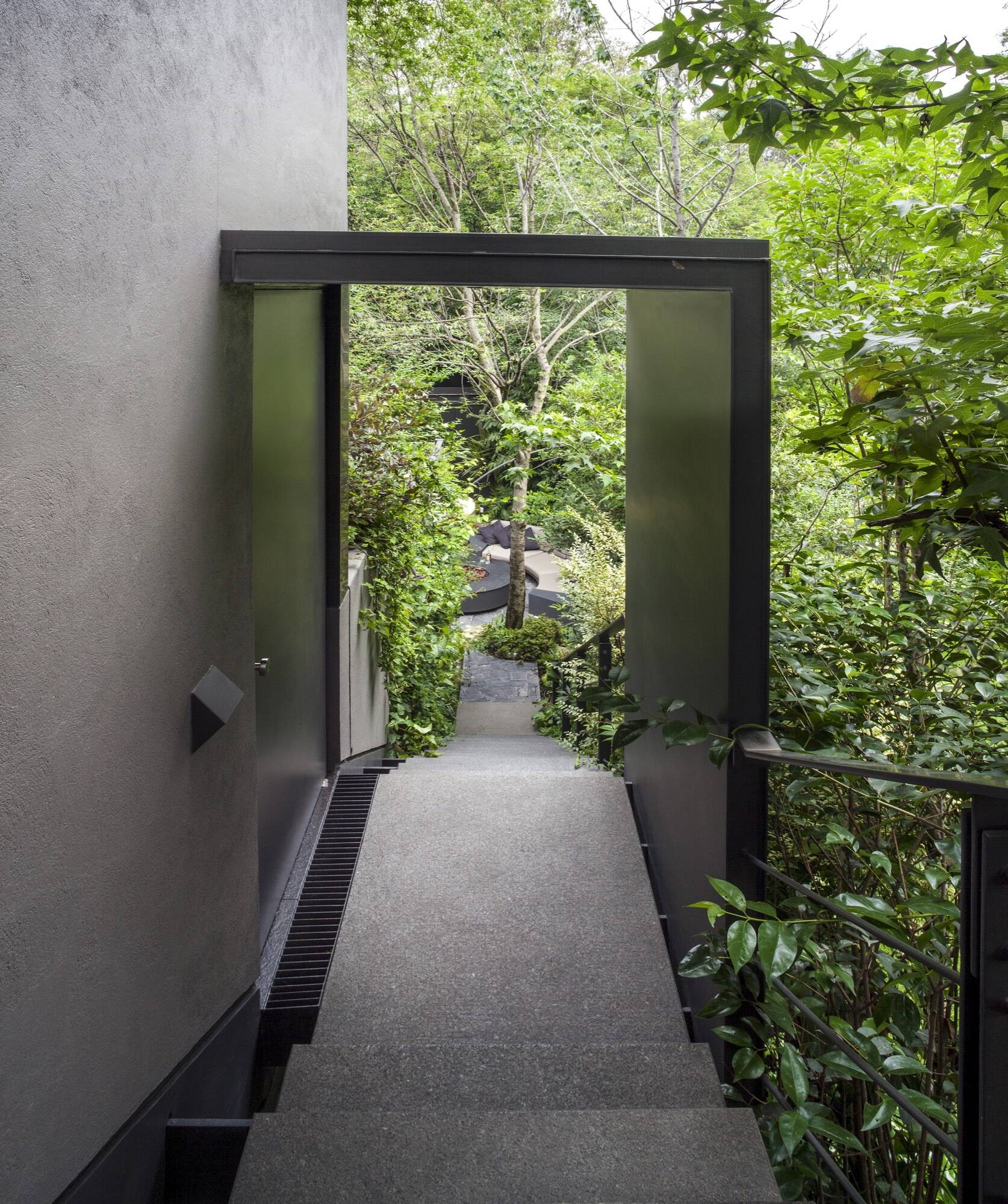 Phía sau mặt tiền đá khép kín, căn biệt thự 420m2 mở ra như một khu rừng nhiệt đới xanh mát và hiện đại